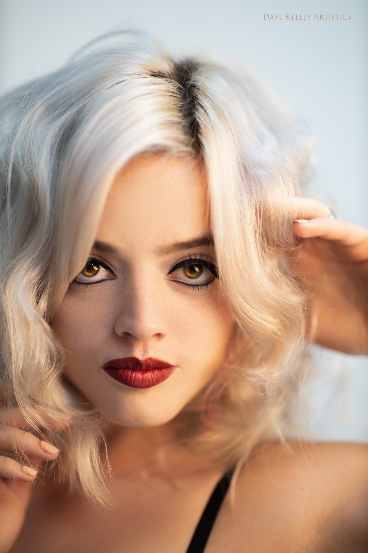 Color beauty portrait of Violet with softly waved platinum hair and red lipstick.